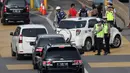Petugas mengarahkan kendaraan berplat genap berputar balik di Gerbang Tol Bekasi Barat 1, Bekasi, Jawa Barat, Selasa (13/3). Hari kedua penerapan ganjil genap, masih banyak kendaraan berputar balik di gerbang tol tersebut. (Liputan6.com/Arya Manggala)