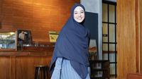 Tampil serba biru dengan kerudung yang cocok dipadukan dress plisket warna biru denim sambil membawa sling bag. [@natasharizkynew]