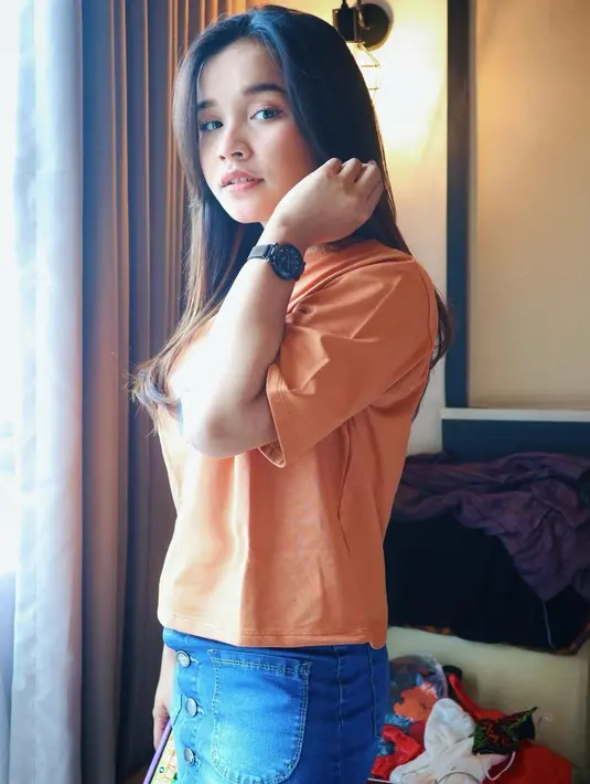 Pedangdut kelahiran 31 Maret 2003 ini tampak elegan saat tampil natural dengan baju kasual. Memakai baju berwarna peach dengan celana jeans biru membuatnya tampil mengagumkan. Rambut indahnya tergerai di bahunya. (Liputan6.com/IG/@tasya_ratu_gopo)