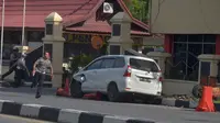 Petugas kepolisian mengamankan mobil yang digunakan terduga teroris setelah serangan di luar markas polisi di Pekanbaru, Riau (16/5). Dalam serangan tersebut satu perwira tewas dan dua lainnya terluka. (AFP Photo/Dedy Sutisna)