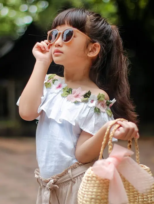 Bergaya bak model memang sudah biasa dilakukan Graciella Abigail saat berfoto. Pakaian warna putihnya terlihat cocok ia kenakan ditambah gaya kecenya yang imut. Pakai kacamat serta menenteng tas menjadi bukti gaya Graciella Abigail ini curi perhatian. (Liputan6.com/IG/@graciellaabigail)