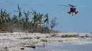 Helikopter Penjaga Pantai AS bersiap untuk mendarat di pantai untuk mengangkut orang-orang dari pulau itu setelah Badai Ian di Pulau Sanibel, Florida, Amerika Serikat, 30 September 2022. Kehancuran yang menimpa Florida menjadi fokus utama sehari setelah badai ini menghantam dengan kategori 4 yang dahsyat, salah satu badai terkuat yang pernah melanda AS. (AP Photo/Steve Helber)