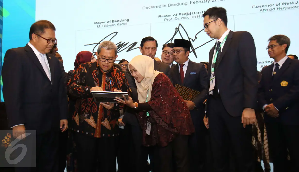 Gubernur Jawa Barat Ahmad Heryawan didampingi Menkominfo Rudiantara mencoba fitur saat Konferensi Internasional dan Pertemuan Tahunan ke-5 OIC Broadcasting Regulation Authorities Forum (IBRAF) di Kota Bandung, Rabu (22/2). (Liputan6.com/Helmi Afandi)