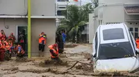 Tim penyelamat memegang tali dalam upaya mengevakuasi kendaraan dan warga yang terjebak banjir di Padang, Provinsi Sumatera Barat pada Kamis 27 November 2025. Badan Penanggulangan Bencana Daerah (BPBD) Kota Padang, Sumatra Barat melaporkan, total 27.433 warga terdampak banjir akibat hujan deras yang mengguyur wilayah tersebut sejak awal pekan lalu. (REZAN SOLEH/AFP)