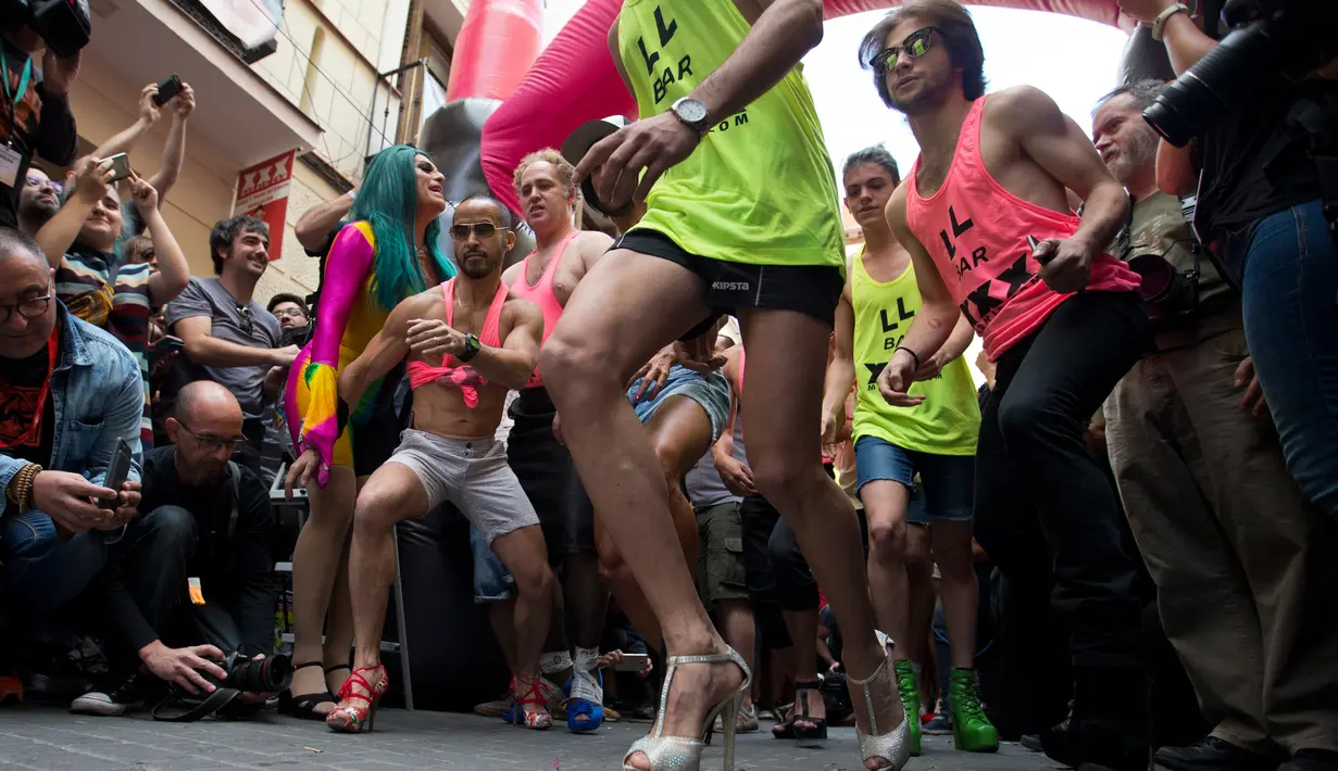 Para peserta mengikuti lomba lari menggunakan sepatu high heels selama peringatan World Pride di distrik Chueca, area populer untuk komunitas gay, di Madrid, Kamis (29/6). World Pride merupakan acara terbesar bagi forum LGBT. (AP Photo/Paul White)