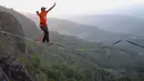 Gambar pada 9 September 2019 memperlihatkan atlet olahraga ekstrem, Andi Ardi berjalan di atas tali yang menggantung di ketinggian 740 meter (2.427 kaki) di Gunung Nglanggeran, Yogyakarta. Aksi itu sebagai bagian dari kampanye pariwisata untuk mempromosikan tempat yang indah. (AGUNG SUPRIYANTO/AFP)