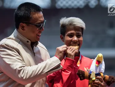 Atlet lompat jauh Indonesia, Rica Oktavia (kanan) foto bersama Menpora Imam Nahrawi usai meraih medali emas Asian Para Games 2018 di SUGBK, Jakarta, Senin (8/10). Rica menorehkan lompatan mencapai 5,25 meter. (Bola.com/Vitalis Yogi Trisna)