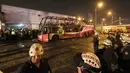 Petugas kepolisian berdiri dekat kerangka  bus bertingkat yang hangus terbakar di terminal bus antarprovinsi, kota Lima, Peru, Minggu (31/3). Pihak berwenang masih menyelidiki penyebab pasti mengapa bus yang penuh penumpang itu ludes dilalap api. (Photo by Luka GONZALES / AFP)