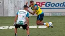 Bintang sepak bola Brasil, Neymar (kanan) menggocek lawan dalam turnamen untuk badan amal Neymar Junior Project Institute di Praia Grande, Sao Paulo, Brasil, Sabtu (21/7). (Miguel SCHINCARIOL/AFP)