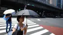 Seorang wanita melindungi dirinya dari matahari dengan payung selama gelombang panas di Tokyo, Jepang (1/8/2019). Selain Tokyo, Kota Tajimi di Perfektur Gifu, Kota Kyoto, dan Kota Hatoyama di Perfektur Saitama juga menjadi wilayah terpanas di Jepang. (AFP Photo/Charly Triballeau)