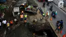 Pengendara melintas dekat perbaikan jalan ambles di Jalan Daan Mogot, Tangerang, Senin (13/1/2020). Amblesnya jalan penghubung ke Jakarta ini diduga karena adanya kebocoran pipa PDAM Tirta Kerta Raharja milik Pemkab Tangerang yang mengikis struktur tanah. (merdeka.com/Magang/Muhammad Fayyadh)