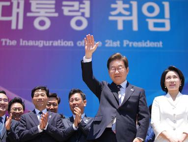 Presiden Korea Selatan Lee Jae-myung (mengangkat tangan) bersama istrinya Kim Hye-kyung saat bersiap untuk meninggalkan tempat setelah upacara pelantikan di Majelis Nasional di Seoul pada 4 Juni 2025. (Lee Jin-man/POOL/AFP)