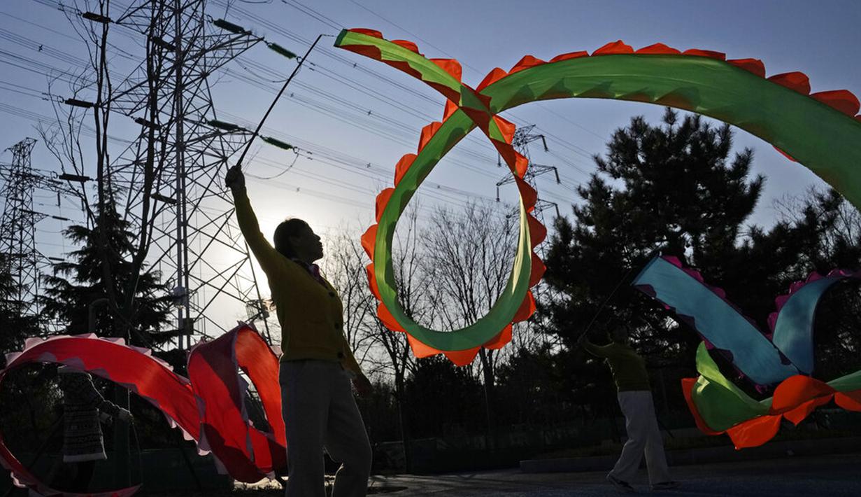 Warga berolahraga dengan pita berwarna di Beijing, China, Selasa (11/1/2022). Beijing dalam siaga tinggi menjelang Olimpiade Musim Dingin saat China mengunci kota ketiga di tempat lain akibat COVID-19. (AP Photo/Ng Han Guan)
