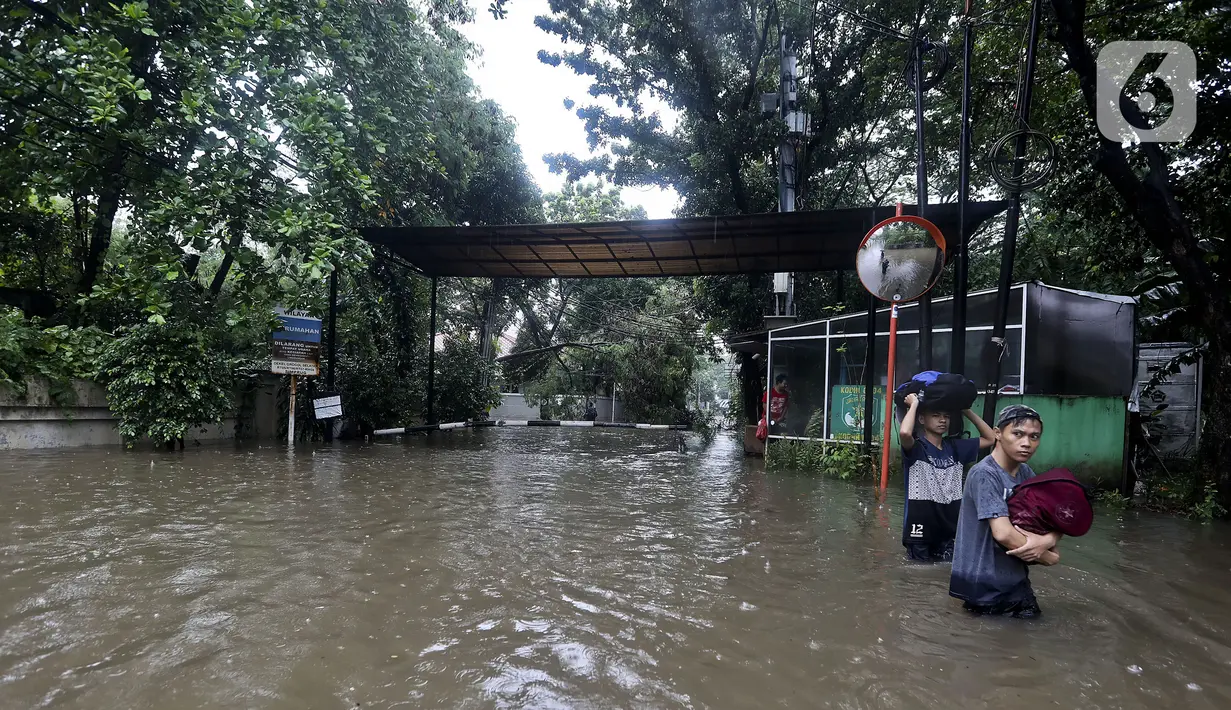 Warga melintasi banjir di Jalan Hang Lekir, Kebayoran Lama, Jakarta Selatan, Rabu (1/1/2020). Banjir tersebut disebabkan karena tingginya intensitas hujan yang mengguyur sejak Selasa (31/12/2019). (Liputan6.com/Johan Tallo)