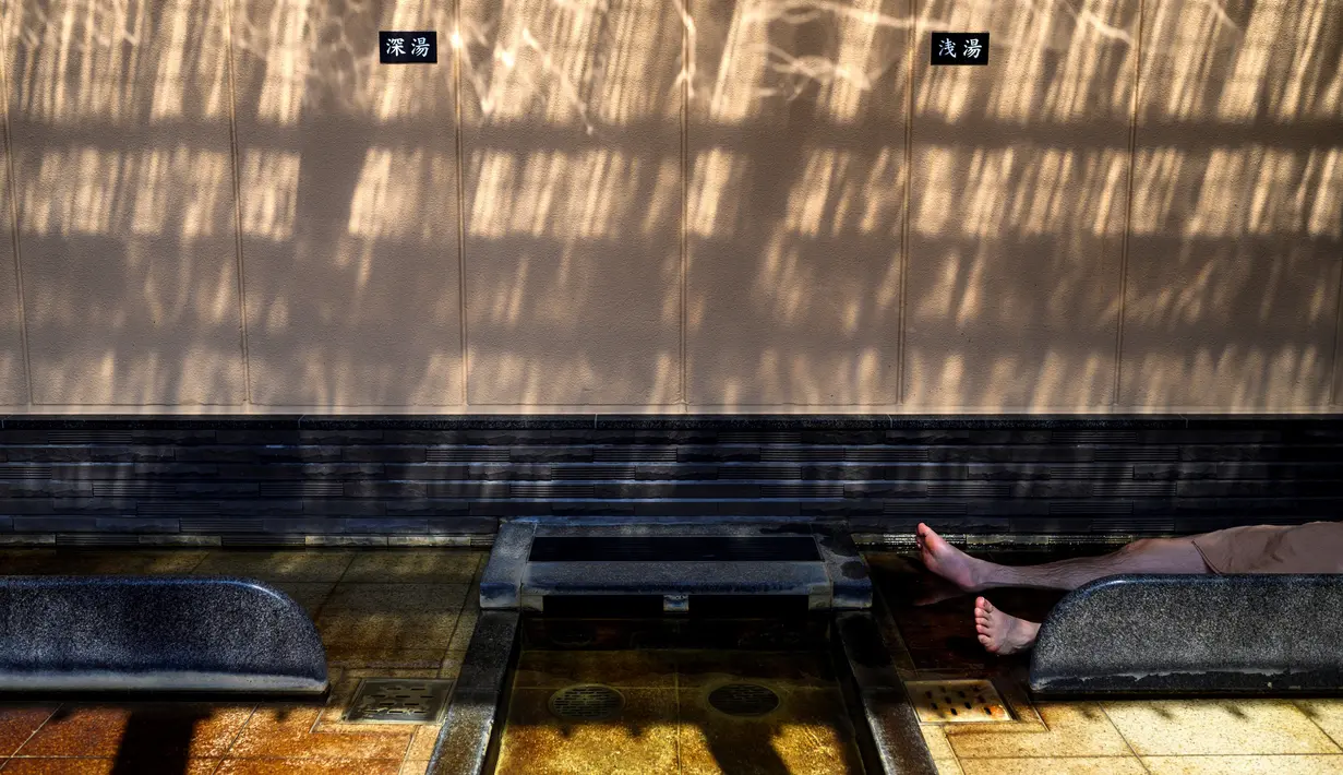 Seorang pria bersantai indoor di pemandian air panas Jepang atau onsen di Yokohama, prefektur Kanagawa pada 29 Mei 2020. Dengan pencabutan status darurat nasional secara resmi pada Senin (25/5) lalu, banyak bisnis yang mulai beroperasi kembali tak terkecuali dengan onsen. (Behrouz MEHRI/AFP)
