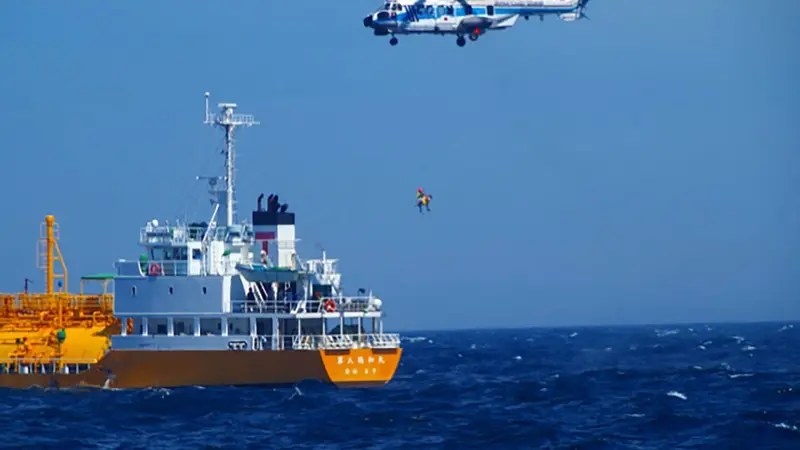 Helikopter penjaga pantai Jepang mengangkat seorang perempuan yang hanyut tersapu ombak ke Semenanjung Boso di Chiba, dari kapal tanker yang menyelamatkan pada 10 Juli 2024. (Handout/Japan Coast Guard Yokosuka Office/AFP