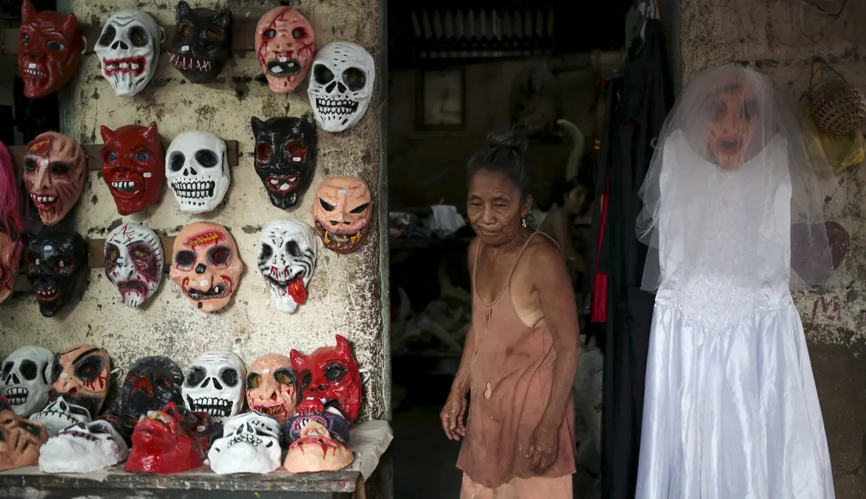 Wanita penjual topeng - topeng yang mengerikan selama perayaan festival Los Aguizotes di Masaya, Nikaragua, Jumat (18/10/2015).  Festival  ini menganjurkan warganya untuk berpakaian layaknya karakter dari legenda dan mitologi.  (REUTERS/Oswaldo Rivas)