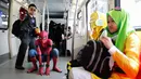 Cosplayer berkostum Spiderman dan Iron Man berpose sambil menaiki Light Rail Transit saat acara cosplay di Kuala Lumpur, Malaysia, Sabtu, 8 Juli 2017. Sejumlah tokoh karakter animasi tiba-tiba muncul di tengah-tengah ruang publik. (AP Photo/Vincent Thian)