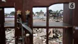 Warga melintasi lahan yang dahulunya permukiman yang terkena gusuran proyek Tol Becakayu, Cipinang Besar Utara, Jakarta, Senin (30/12/2019). Tercatat 900 rumah warga di 3 RW, yakni RW 001, 002, dan 003 Kelurahan Cipinang Besar Utara terkena gusuran proyek Tol Becakayu. (merdeka.com/Iqbal S. Nugroho)