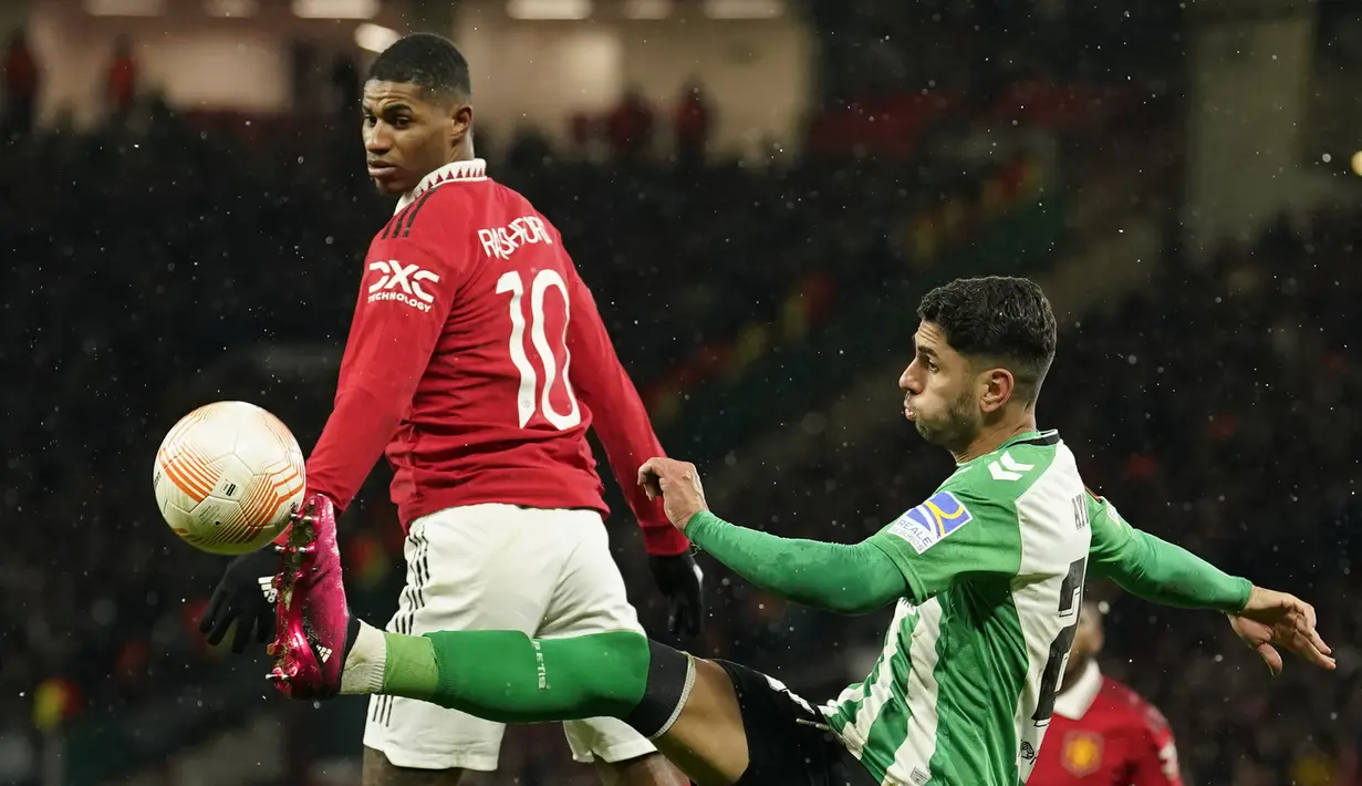 Penyerang Manchester United atau MU, Marcus Rashford berebut bola dengan penyerang Real Betis, Ayoze Perez pada leg pertama 16 besar Liga Eropa 2022/2023 di Old Trafford, Jumat dini hari WIB (10/3/2023). Real Betis sendiri sempat menyamakan kedudukan lewat gol Ayoze Perez. (AP Photo/Dave Thompson)