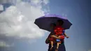 Seorang korban gempa menggendong anaknya mengantre untuk  mendapatkan makanan dan minuman di lokasi pengungsian, di Kathmandu, Nepal, Senin (4/5/2015). Gempa berkekuatan 7,8 yang meluluhlantakkan Nepal pada 25 April 2015 lalu. (REUTERS/Adnan Abidi)