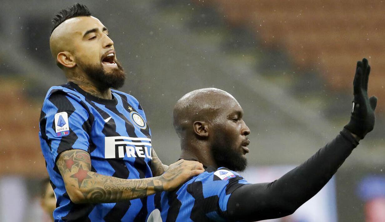 Striker Inter Milan, Romelu Lukaku, melakukan selebrasi bersama Arturo Vidal usai membobol gawang Spezia pada laga Liga Italia di Stadion Giuseppe Meazza, Minggu (20/12/2020). Inter Milan menang dengan skor 2-1. (AP/Luca Bruno)
