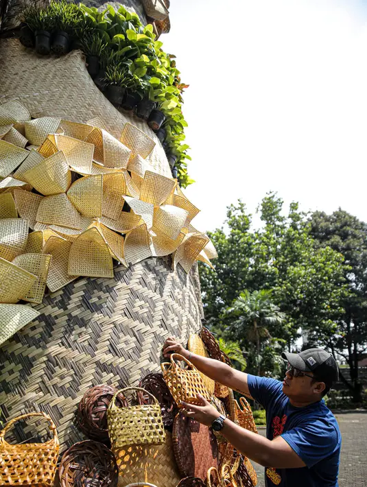 Umat nasrani mendekorasi Natal di Gereja Katolik Santo Stefanus, Jakarta, Selasa (20/12/2022). Pada perayaan Natal 2022 dengan mengusung tema “Green Christmas” mereka membuat pohon Natal dari gedek, tampah, besek sedangkan ornamen goa Natal menggunakan barang bekas pakai karton telur, selongsong tissue gulung, serta buku misa paskah 2019. (Liputan6.com/Faizal Fanani)