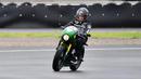 Jokowi mengendarai motor custom dengan warna hijau garapan Katros Garage. Dia mengenakan setelan jaket hitam dan sepatu sneakers saat menjajal sirkuit Mandalika. (Istana Kepresidenan/Agus Suparto)