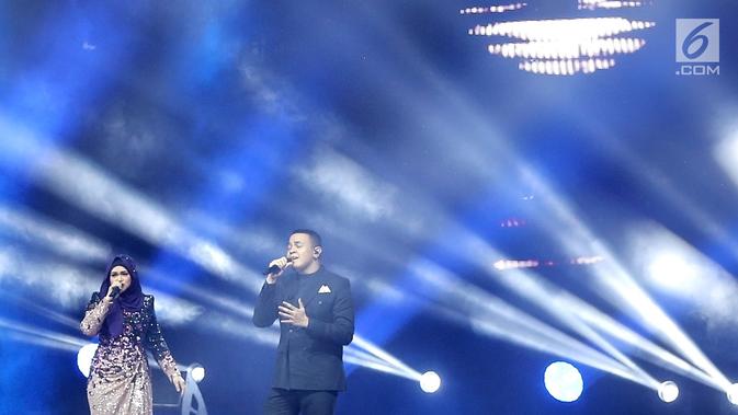 Penyanyi Siti Nurhaliza (kiri) berduet dengan Tulus dalam konser 'Dato Sri Siti Nurhaliza on Tour' di Istora Senayan, Jakarta, Kamis (21/2). Tulus mengaku sangat senang karena bisa berduet dengan legenda musik seperti Siti. (Fimela.com/Bambang E Ros)