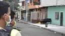 Polisi melihat ke arah jenazah yang diduga meninggal karena virus corona COVID-19 di teras sebuah rumah di pinggiran Guayaquil, Ekuador, Jumat (3/4/2020). Hingga 6 April 2020, tercatat ada 3.646 kasus positif COVID-19 di Ekuador dengan angka kematian sebesar 180 orang. (AP Photo/Edison Choco)