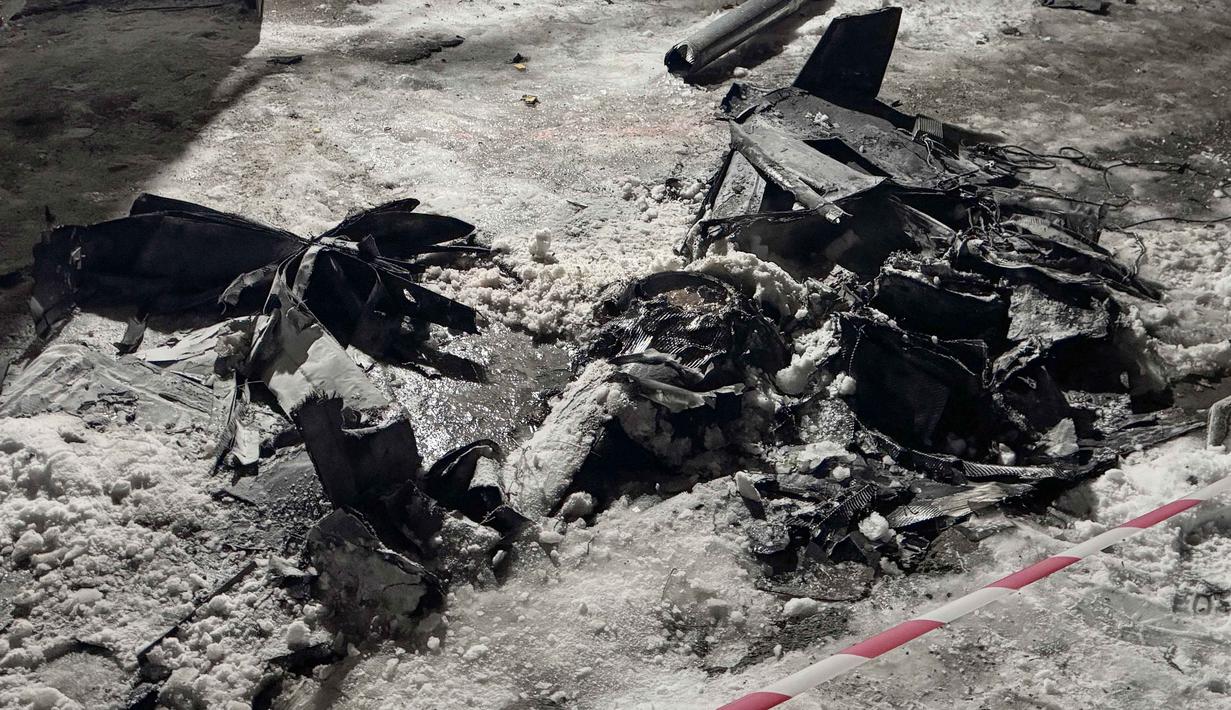 Belum ada laporan resmi mengenai korban jiwa. Tampak sebuah foto yang menunjukkan puing-puing drone di dekat bangunan tempat tinggal yang rusak akibat serangan drone Rusia di Zaporizhzhia pada 2 Januari 2026, di tengah invasi Rusia ke Ukraina. (Darya NAZAROVA/AFP)