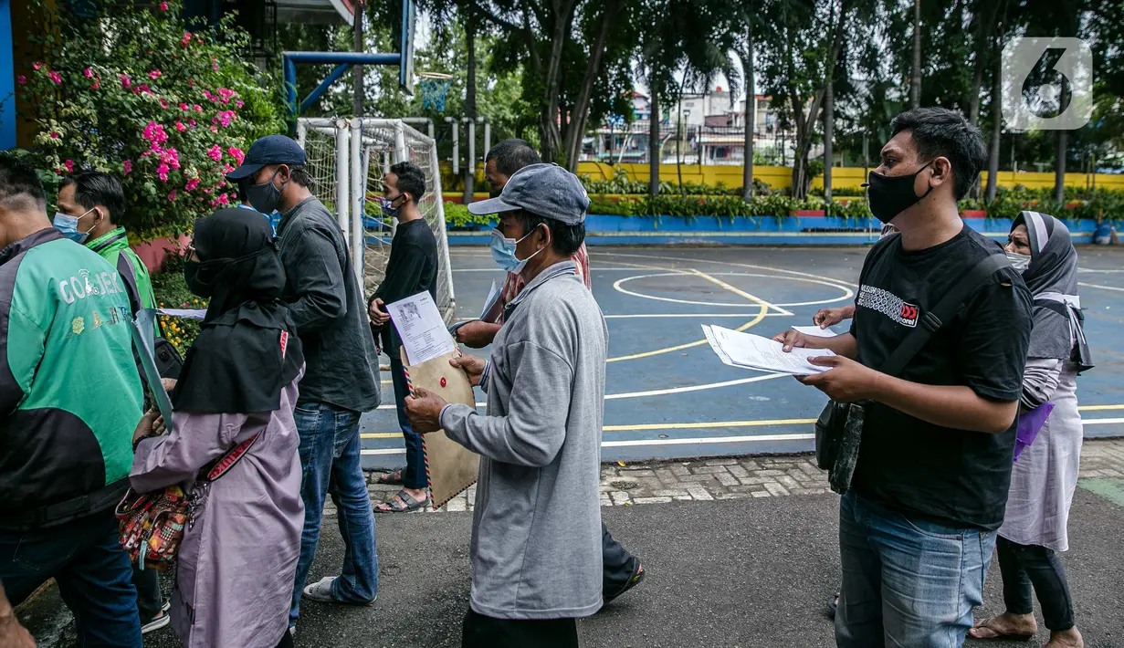 Warga antre untuk mengambil Bantuan Sosial Tunai (BST) di SMAN 111, Jakarta, Selasa (19/1/2021). Pemprov DKI Jakarta menyalurkan BST sebesar Rp 300 ribu kepada 1.055.216 KK mulai Januari hingga April 2021. (Liputan6.com/Faizal Fanani)