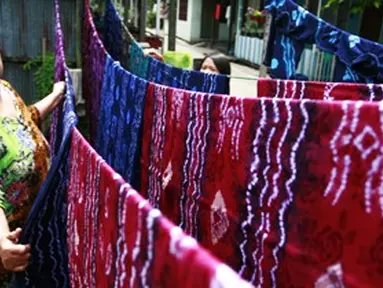 Citizen6, Banjarmasin: Seorang pengrajin menjemur kain sasirangan yang selesai diwarnai.