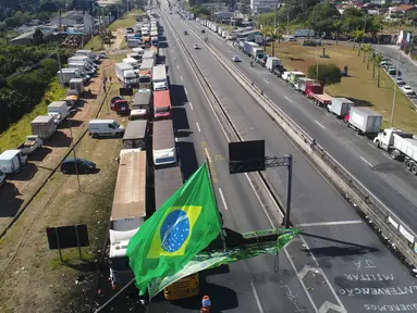 Ribuan truk diparkir di bahu Jalan Raya Federal BR-116 untuk memprotes kenaikan biaya bahan bakar (BBM) di Embu das Artes, pinggiran Sao Paulo, Brasil, Senin (28/5). Aksi ini menyebabkan  kurangannya pasokan BBM di SPBU. (AP Photo/Andre Penner)