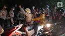 Pemudik motor melewati barisan polisi saat melintas di posko penyekatan mudik di Kedungwaringin, Kabupaten Bekasi, Jawa Barat, Selasa (11/5/2021) dini hari. Bila sudah terjadi penumpukan, kendaraan akan dialirkan ke titik-titik berikutnya. (Liputan6.com/Herman Zakharia)