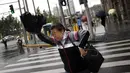 Seorang wanita menahan payung saat Topan Fung-Wong melintasi daerah dekat pesisir Shanghai, Tiongkok, (23/9/2014). (REUTERS/Carlos Barria)