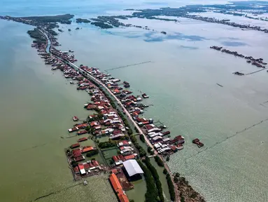 Foto yang diambil pada 30 Juli 2025 menunjukkan pemandangan udara rumah-rumah yang sebagian terendam akibat kehilangan lahan akibat perubahan iklim di Desa Bedono, Demak, Jawa Tengah. (BAY ISMOYO/AFP)