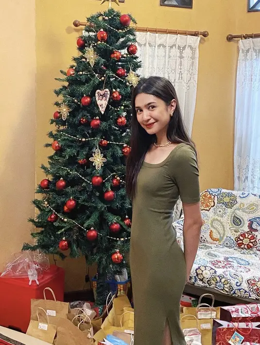 Merayakan Natal, Mikha mengenakan slit dress ketat hijau army yang memerlihatkan perut ratanya, seperti tidak ada lemak di perutnya tersebut. (@miktambayong)