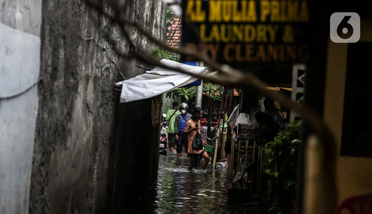 Aktivitas warga saat banjir merendam lingkungan rumah tempat tinggal mereka di kawasan kecamatan Kebayoran Baru, Jakarta, Senin (25/01/2021). Hujan deras yang mengguyur Jakarta hari ini, Senin (25/1) menyebabkan terjadinya banjir di kawasan permukiman tersebut. (Liputan6.com/Johan Tallo)