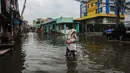Warga melintasi banjir rob yang terjadi di kawasan Muara Baru, Jakarta Utara, Selasa (14/1/2025). (Liputan6.com/Angga Yuniar)