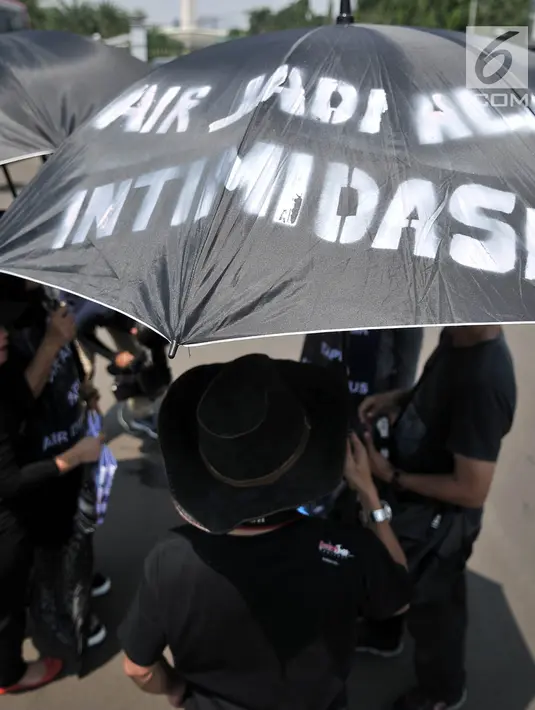 Massa dari Komite Warga Sentul City mengenakan payung hitam dalam aksi di depan Istana Negara, Senin (30/4). Mereka meminta proses hukum terhadap pengembang perumahan Sentul City karena diduga terjadi penguasaan pengelolaan air (Merdeka.com/Iqbal Nugroho)