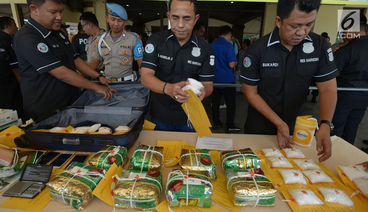 Petugas menata barang bukti dalam rilis kasus narkotika jenis sabu di Mapolres Metro Jakarta Utara, Selasa (6/8/2019). Polisi mengamankan tersangka berinisial DA dengan total barang bukti 10 kg sabu, mobil Toyota Altis, 3 kunci kamar kosan, 4 handphone, serta alat timbangan. (merdeka.com/Imam Buhori