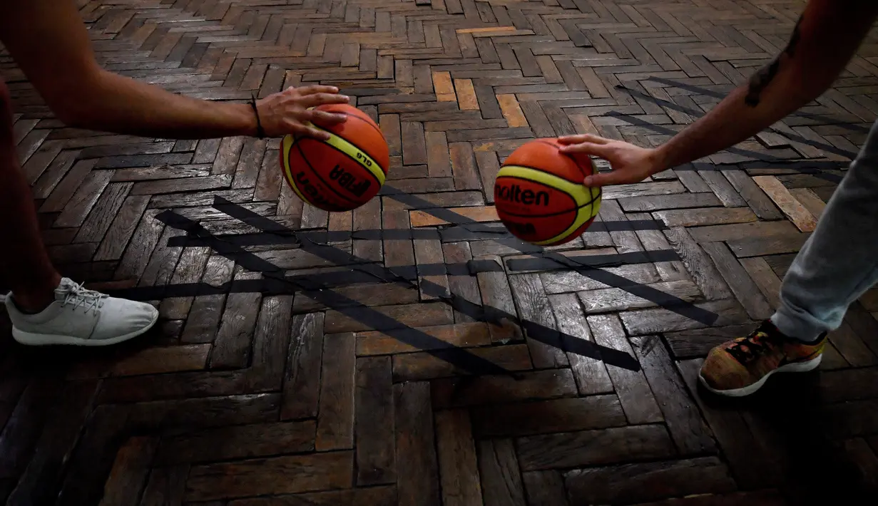 Pemain memainkan bola saat berlatih di lapangan basket tertua di dunia di Paris, Prancis, Kamis (31/5). (GERARD JULIEN/AFP)