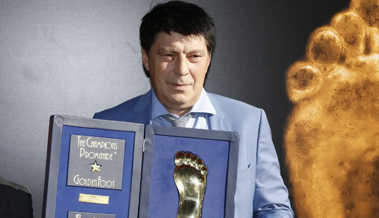 Kiper Rusia Rinat Dasaev berpose dengan trofi Golden Foot miliknya, Monaco, Senin (21/9/2015). Golden Foot 2015 diraih lima orang yaitu Rinat Dasaev, Daniel Passarella, Gheorghe Hagi,  Trezeguet dan Eto'o. (AFP Photo/Valery Hache)