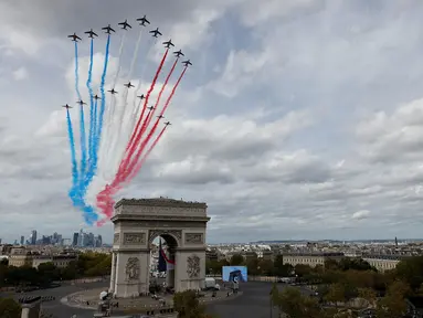 Tim terbang akrobatik Angkatan Udara Prancis "Patrouille de France" (PAF) dan tim aerobatik Angkatan Udara Kerajaan Inggris (RAF), "Red Arrows", melakukan terbang lintas selama upacara penyambutan resmi untuk Raja Inggris Charles III dan Ratu Inggris Camilla di Arc de Triomphe di Paris pada tanggal 20 September 2023. (Geoffroy Van der Hasselt/AFP)