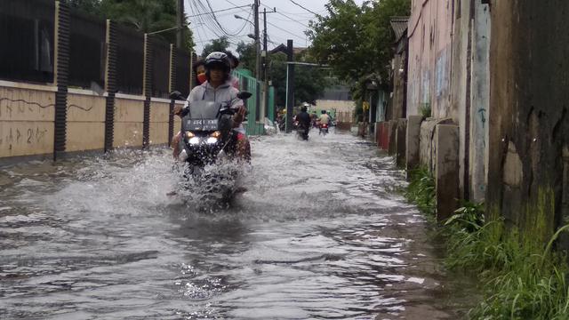 Warga berjalan menerobos banjir setinggi satu meter di Perumahan Rawalumbu Utara BBU Pasar Burung, Kota Bekasi. Foto: Liputan6.com/Bam Sinulingga)