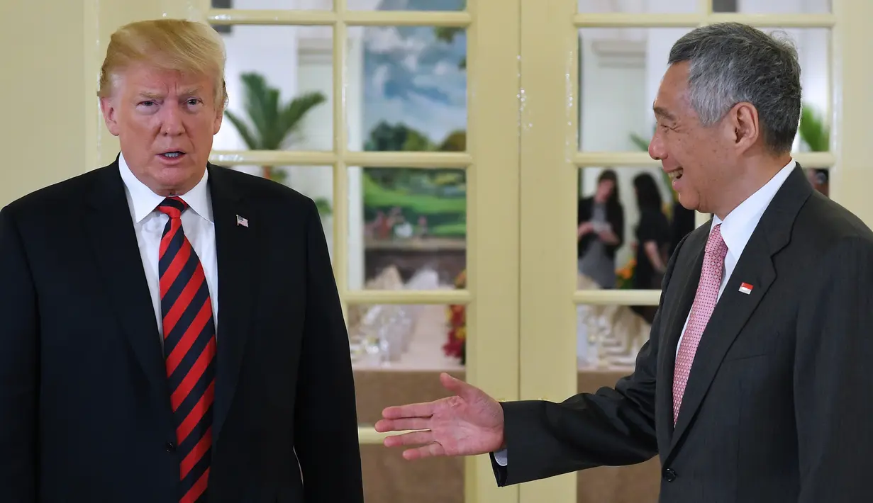 Presiden AS Donald Trump (kiri) bersama PM Singapura Lee Hsien Loong (kanan) saat akan makan siang bersama di Istana Negara Singapura, Senin (11/6). Trump akan bertemu dengan Pemimpin Korea Utara Kim Jong-un dalam acara KTT Korut-AS. (SAUL LOEB/AFP)