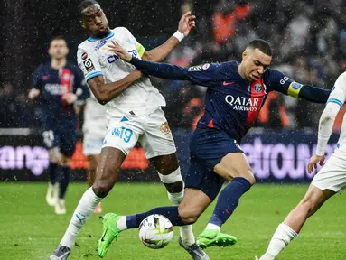 Pemain Paris Saint-Germain, Kylian Mbappe, berebut bola dengan pemain Marseille, Geoffrey Kondogbia, dalam duel pekan ke-27 Ligue 1 2023/2024 di Stade Velodrome, Senin (1/4/2024). PSG menang dengan skor 2-0. (AFP/Christophe Simon)