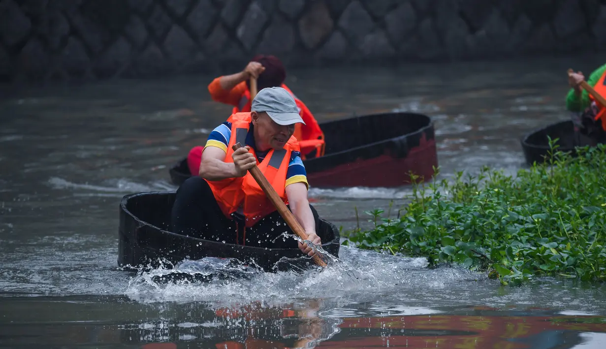 Warga desa berpartisipasi dalam kontes mendayung ember di Desa Quanxin, Kota Huzhou, Provinsi Zhejiang, China, Selasa (23/6/2020). Ember purun tikus (water chestnut) merupakan alat kerja tradisional yang dimiliki setiap rumah tangga di kota-kota perairan di China. (Xinhua/Xu Yu)