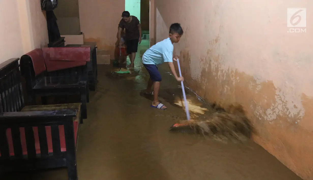 Warga membersihkan rumah mereka akibat banjir yang melanda Kampung Melayu, Jakarta Timur, Senin (25/6). Banjir kiriman ini terjadi akibat hujan deras yang mengguyur wilayah Bogor sejak kemarin. (Liputan6.com/Arya Manggala)